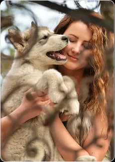 A woman hugging a husky puppy
