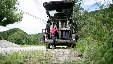 A volunteer sitting in the open back of a transport van