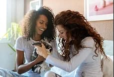 Two women holding a kitten