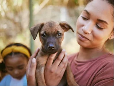 A woman and a girl holding a puppy