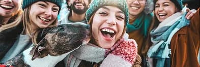 Laughing friends outdoors with their dog