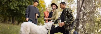 People gathered outdoors in a park with an animal