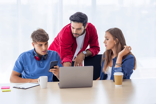 A team working together around a laptop