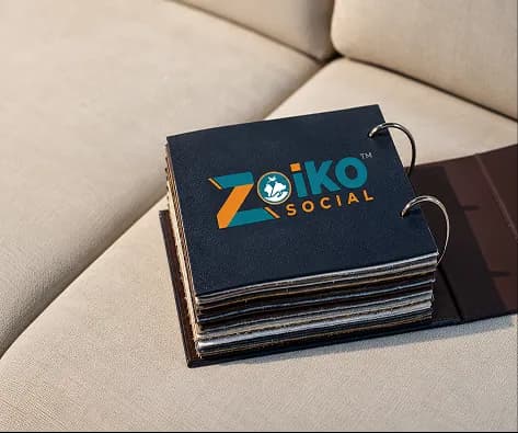 A Zoiko Social branded binder of swatches on a sofa