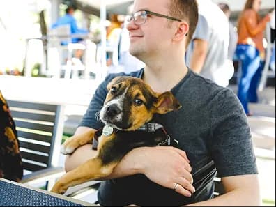A man holding a puppy at an outdoor event