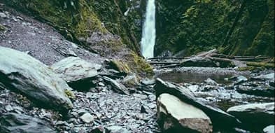 A waterfall falling onto mossy rocks