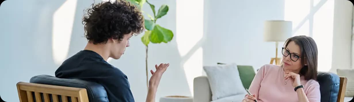 A young man talking with a therapist in a bright room