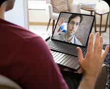 A person on a video call with a therapist on a laptop