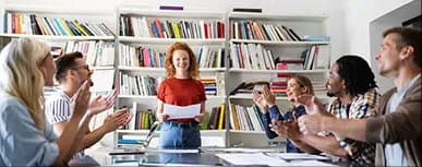 Colleagues applauding a presenter in a library