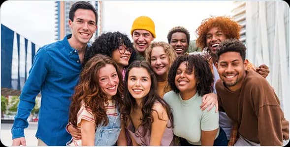 A group of smiling young friends posing together outdoors